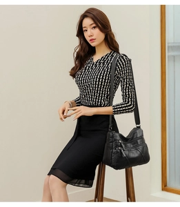 Détail d'un sac bandoulière noir en cuir souple avec plusieurs poches zippées pratiques