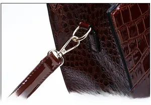 Detail der braunen Kroko-Lederhandtasche mit hochwertigem goldenem Metallverschluss