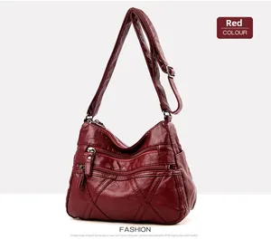 Détail macro du sac à bandoulière rouge foncé en similicuir avec trois poches zippées