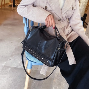 Classic black Boston bag with silver studs and adjustable strap in a lifestyle setting