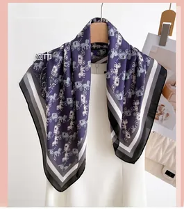 Detail of silk-like scarf with carriage print and striped edges on a hanger