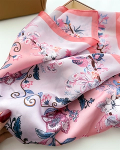 Detail of silk scarf with floral print and satin finish showing soft texture and drape