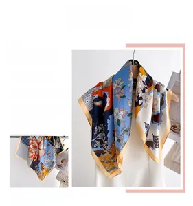 Detail of floral silk scarf showing vibrant blue and orange patterns with yellow hem