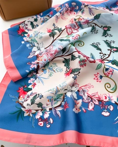 Detailed view of floral silk scarf featuring elegant blue and pink botanical patterns