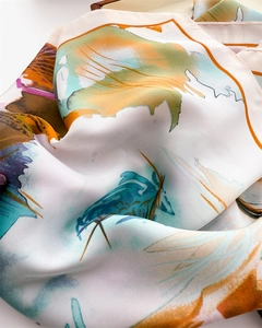 Close-up of silk-like scarf featuring colorful abstract floral print and smooth texture