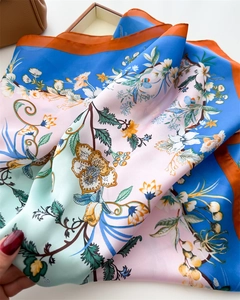 Detail of premium silk square scarf featuring vibrant botanical floral print and smooth texture
