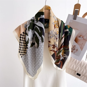 Artistic floral and checkerboard silk scarf draped over a white elegant dress