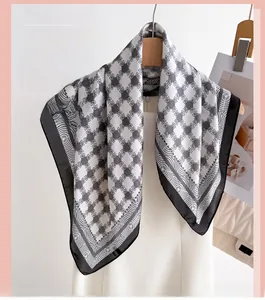Close-up of geometric chain print silk scarf in black and white hanging on a wooden hanger