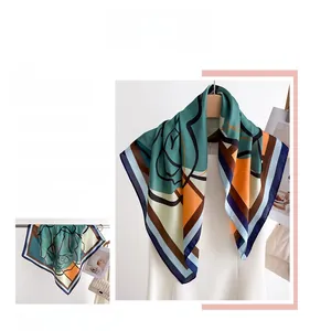 Macro detail of geometric floral silk scarf featuring rich orange and ink green patterns