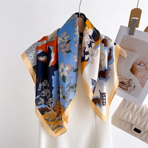 Artistic floral silk scarf with blue and orange geometric patterns on wooden hanger