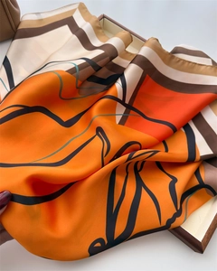 Close-up of silk scarf with orange geometric floral print and abstract black lines