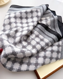Detailed view of the luxury silk scarf showing chain patterns and smooth satin texture
