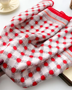 Detailed close-up of geometric silk scarf showing smooth texture and chain patterns