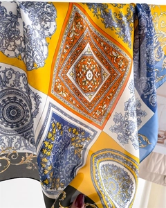 Detailed close-up of Baroque pattern print on a luxury silky scarf with vibrant yellow accents
