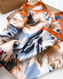 Detailed macro view of abstract oil painting floral silk scarf with bold orange border edge
