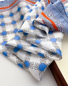 Macro detail of silk scarf showing nautical chain prints and smooth satin texture