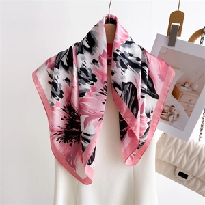 Floral print silk square scarf with pink and black abstract pattern on wooden hanger