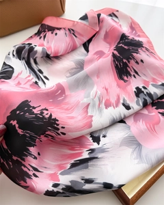 Detail of soft silk scarf with pink and black floral print and elegant satin texture