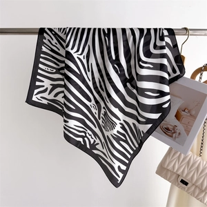 Close-up of zebra print silk scarf hanging with neat black stitched edges on soft background