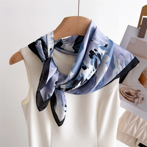 Close-up of elegant blue and purple floral silk scarf tied around a white vest