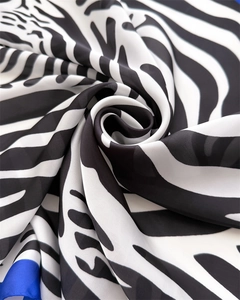 Detail of zebra print silk scarf showing smooth texture and blue border accent