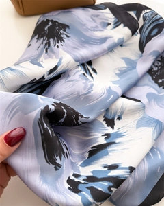 Detailed macro view of vibrant floral print silk scarf with satin luster and soft texture