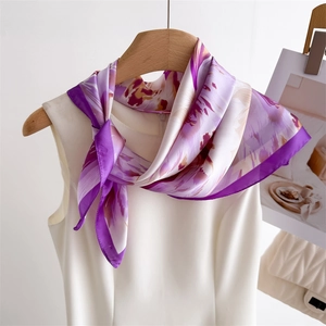 Detail of floral silk scarf tied on a hanger showing the smooth satin fabric texture