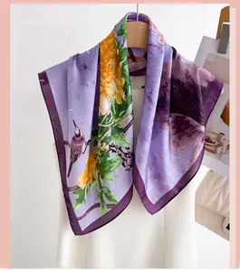 Detail of silk scarf featuring ink lotus flower and bird print with purple borders