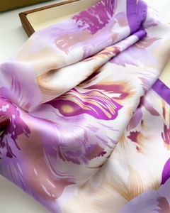 Detailed view of elegant purple and gold floral silk scarf with glossy folded texture