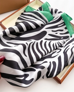 Close-up of zebra print silk scarf featuring premium texture and green borders