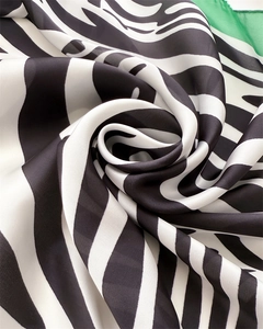Detail of silk zebra print scarf featuring smooth texture and vibrant green edges