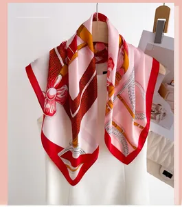 Vue détaillée d'un foulard en soie imprimé équestre avec des motifs floraux et bord rouge