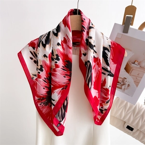 Elegant floral silk square scarf with vibrant red flower print on a wooden hanger