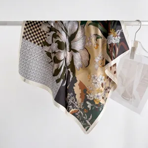 Beige floral silk scarf with checkerboard patterns and large flower prints hanging elegantly