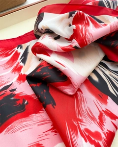 Macro detail of abstract floral silk scarf fabric texture with vibrant red and pink prints