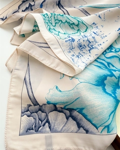 Close-up of ink lotus print silk scarf showing smooth satin texture and fine rolled edges