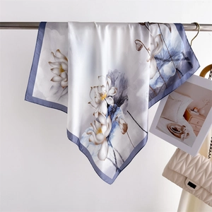 Close-up of silk scarf with Chinese ink lotus print and blue borders on a hanger