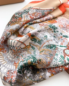 Detail of silk square scarf featuring tropical palm leaves and floral illustration prints