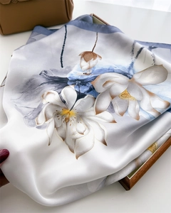 Detailed view of white silk scarf with ink lotus floral print and dark blue hem