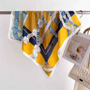 Vue détaillée du foulard en soie jaune et bleu avec imprimé équestre et boucles en métal