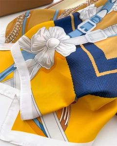 Vue détaillée du foulard en soie à imprimé équestre montrant des motifs de boucles chic
