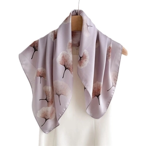 Elegant lavender silk scarf with ginkgo leaf print draped on a white dress