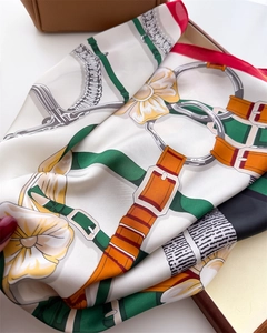 Détail d'un foulard en soie de luxe avec imprimé équestre et fleurs dans un coffret