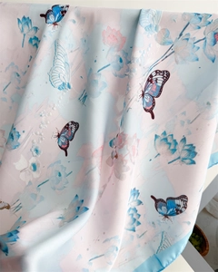 Detail of silk scarf with elegant butterfly and lotus patterns in pink and blue