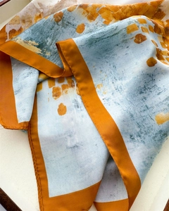 Close-up of vintage silk square scarf with orange borders and abstract watercolor print