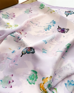 Detail of silk scarf with lotus and butterfly patterns on elegant light purple fabric