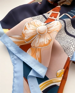 Détail du foulard en soie avec imprimé équestre et texture satinée brillante