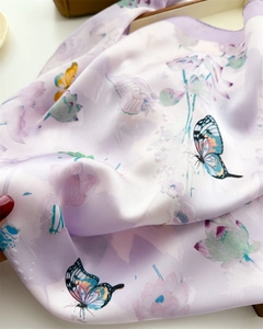 Detailed macro shot of lavender silk scarf featuring vivid butterfly and lotus patterns