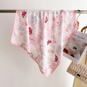 Detail of pink floral silk scarf with butterfly print hanging near a quilted chain handbag