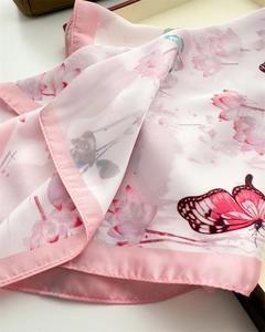 Detailed macro view of the floral silk scarf with pink lotus and butterfly patterns